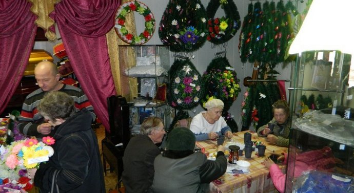 Tè per veterani tra corone funebri e bare